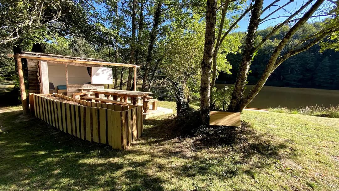 Cabane au bord d’un étang de pêche en pleine forêt 