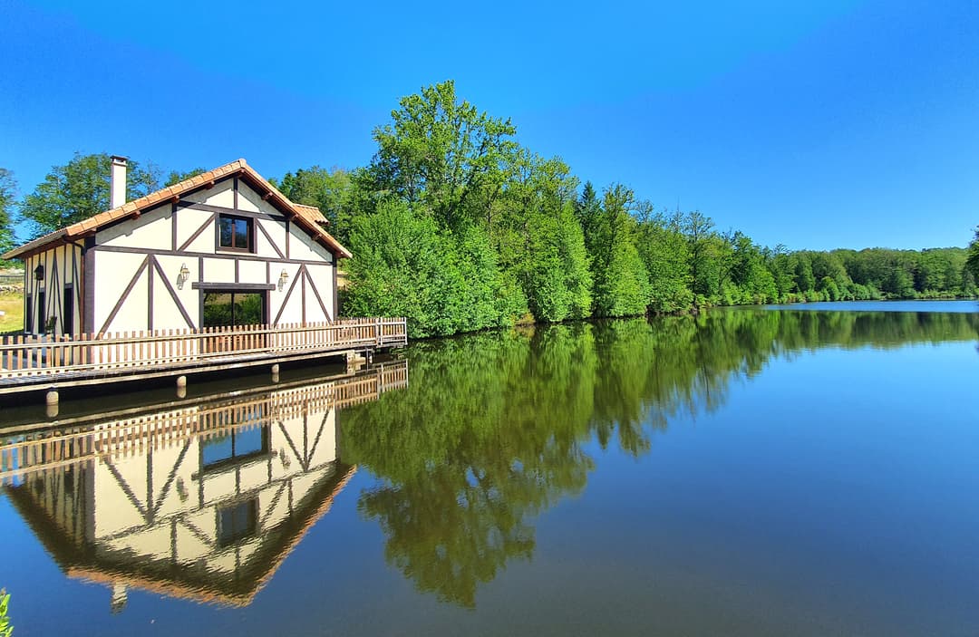 Chalet au bord de l’eau, terrasse sur pilotis sur étang de pêche privé en pleine nature en Dordogne