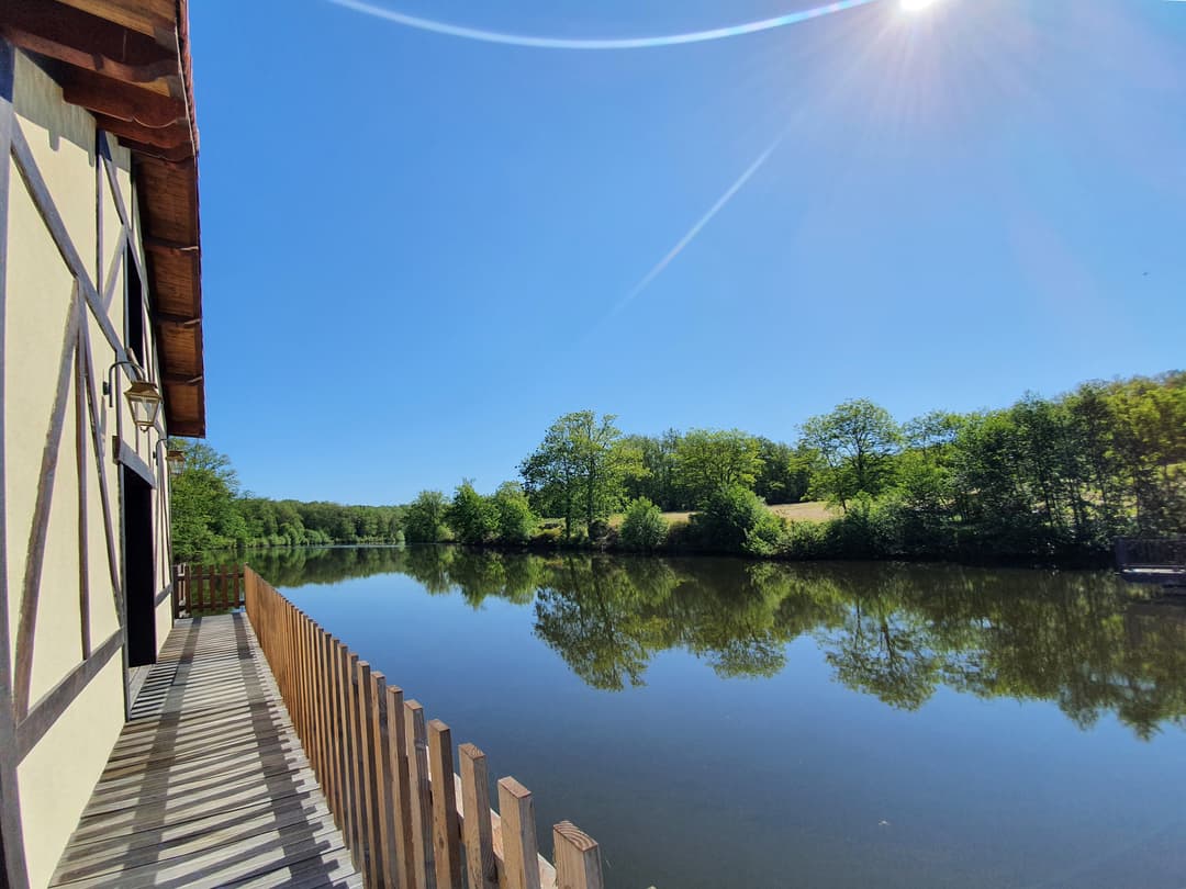 Chalet au bord de l’eau, terrasse sur pilotis sur étang de pêche privé en pleine nature en Dordogne