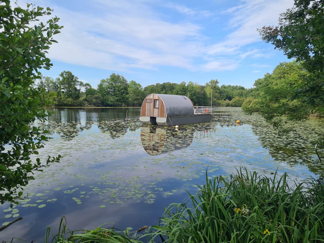Etang avec bateau cabané au cœur d'un élevage piscicole