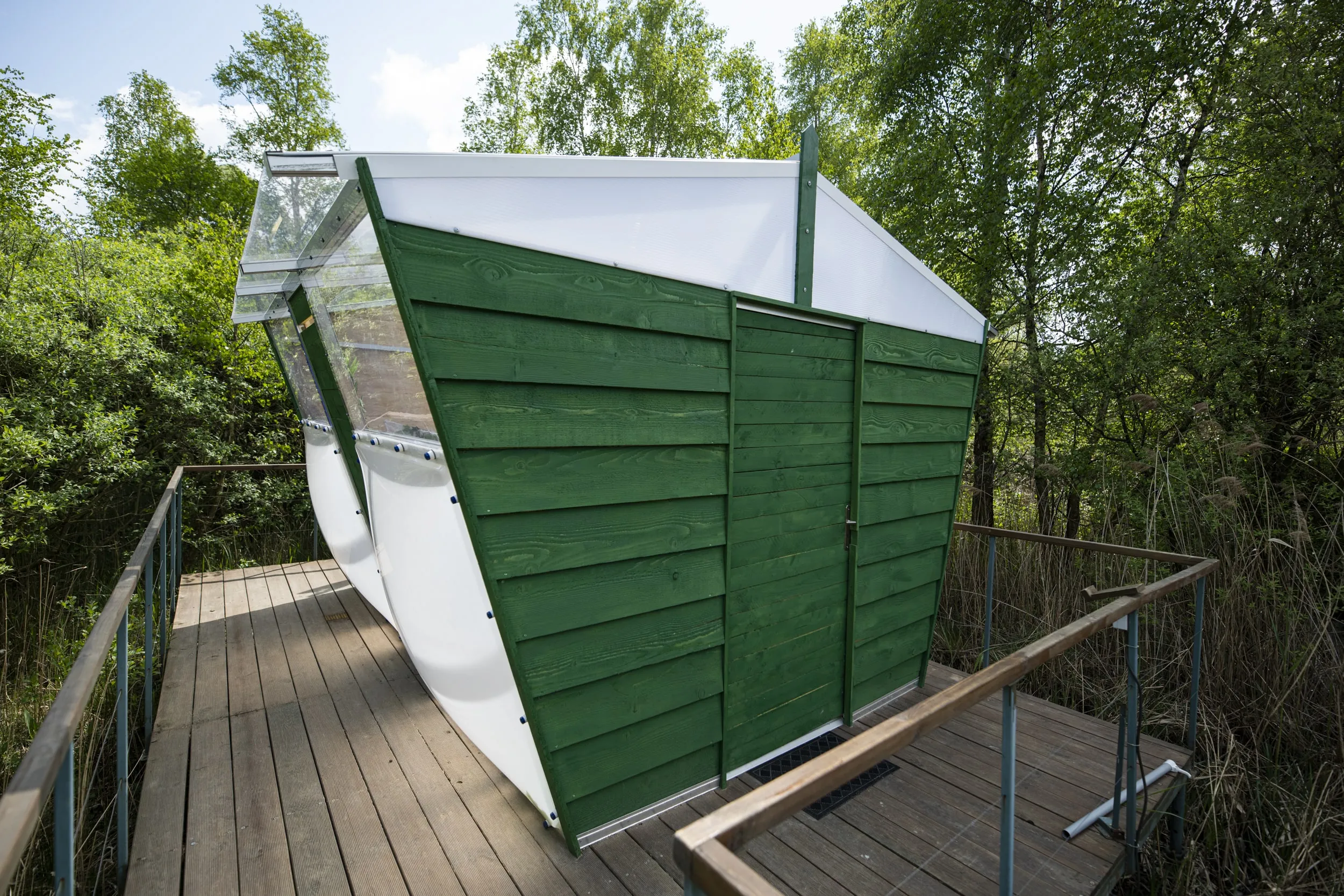 Cahute transparente au cœur de la nature avec étang