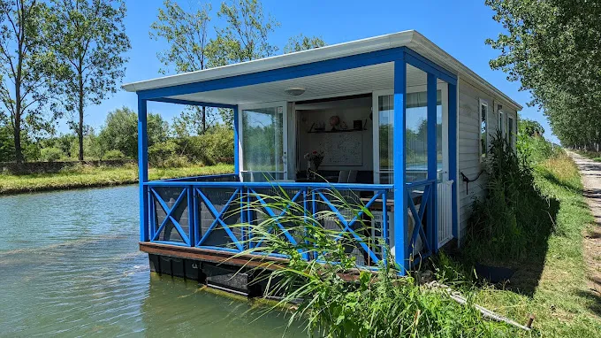 Blue barge rental by a canal with jacuzzi
