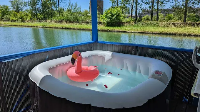 Blue barge rental by a canal with jacuzzi