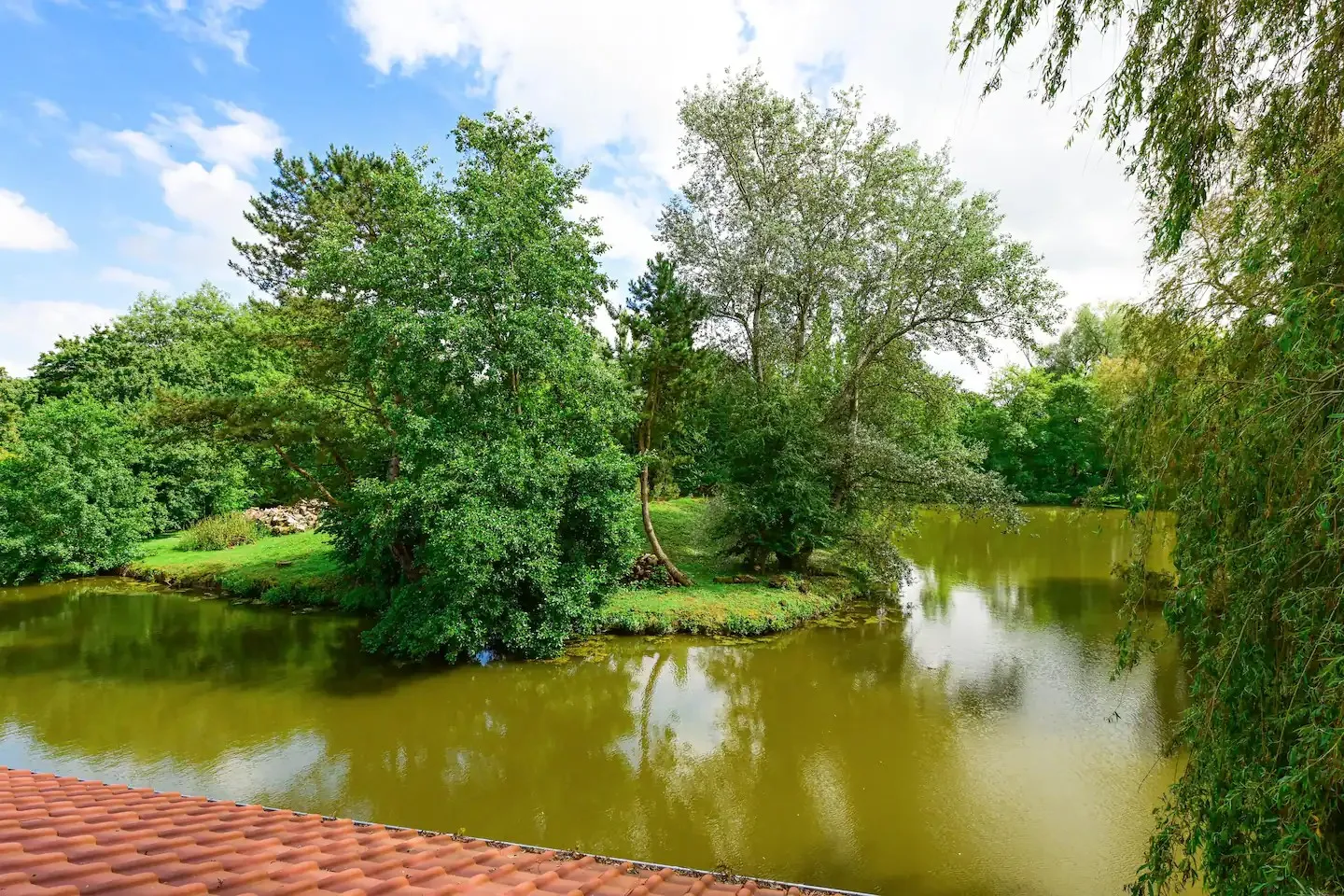 A house hanging on the water of its private pond